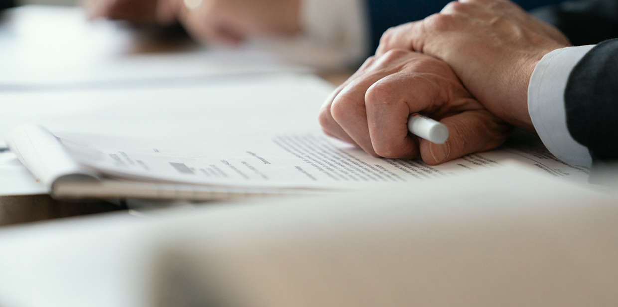 Attorney holding a pen over documents on a table