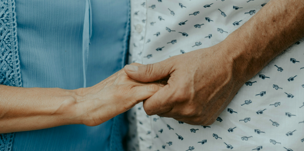 Close-up of an elderly couple holding hands