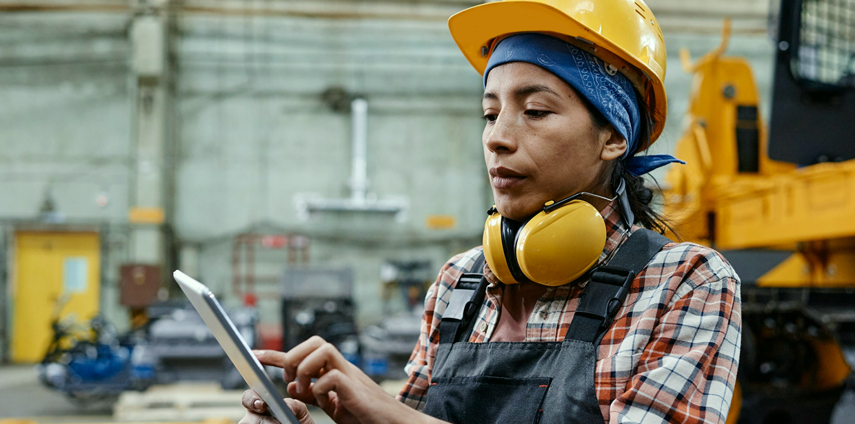 Industrial worker in a hard hat using a tablet on the job