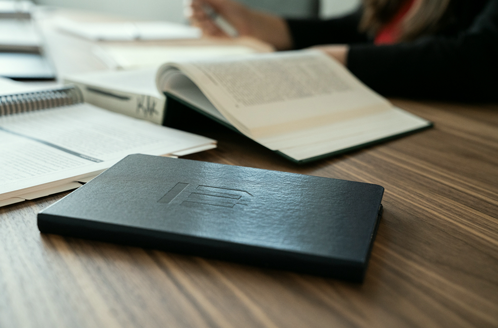 Law books and a leather notebook on a wooden desk