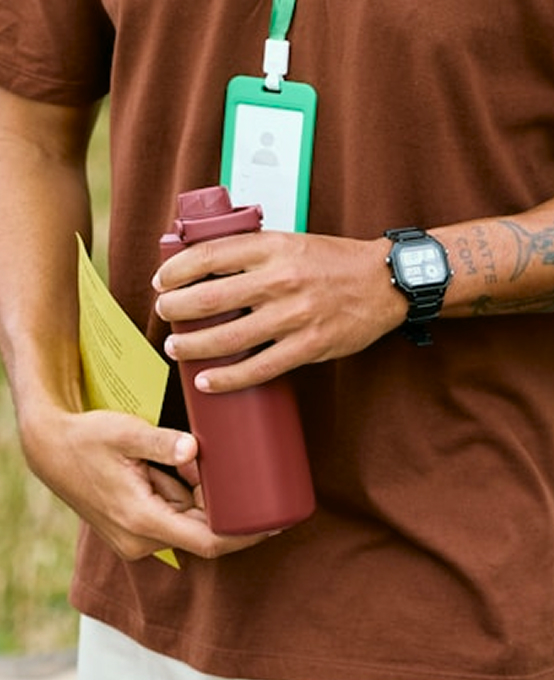 Worker holding a water bottle and a lanyard badge