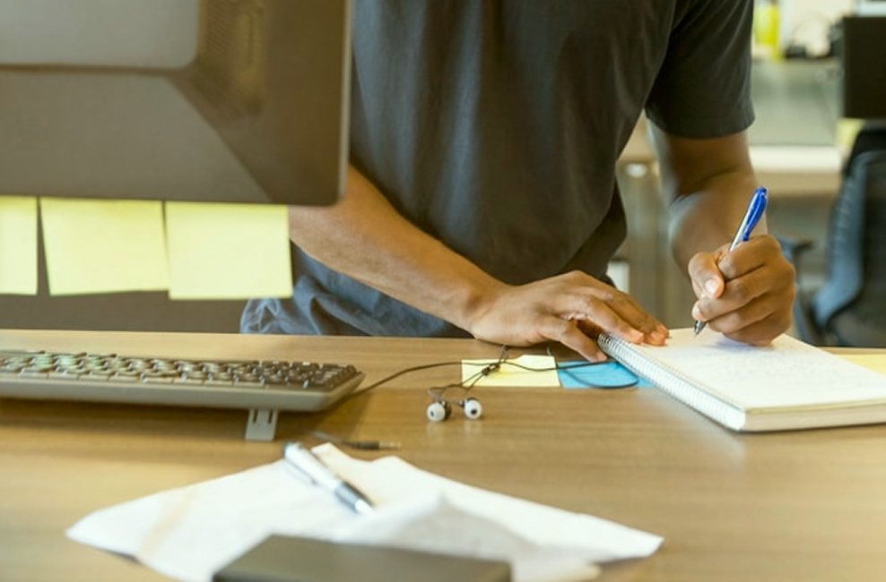 Man writing down a note at a desk