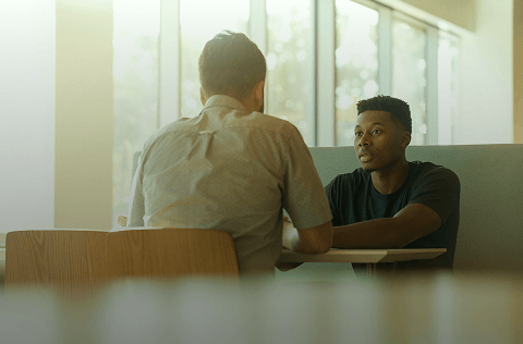 Two people speaking across a table