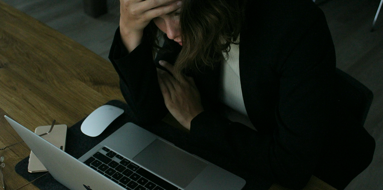 Woman working late at a laptop in a dim office