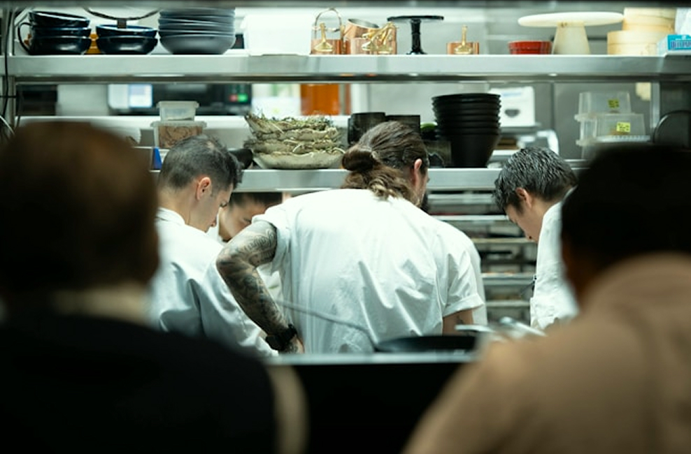 Kitchen workers preparing food together on a shift
