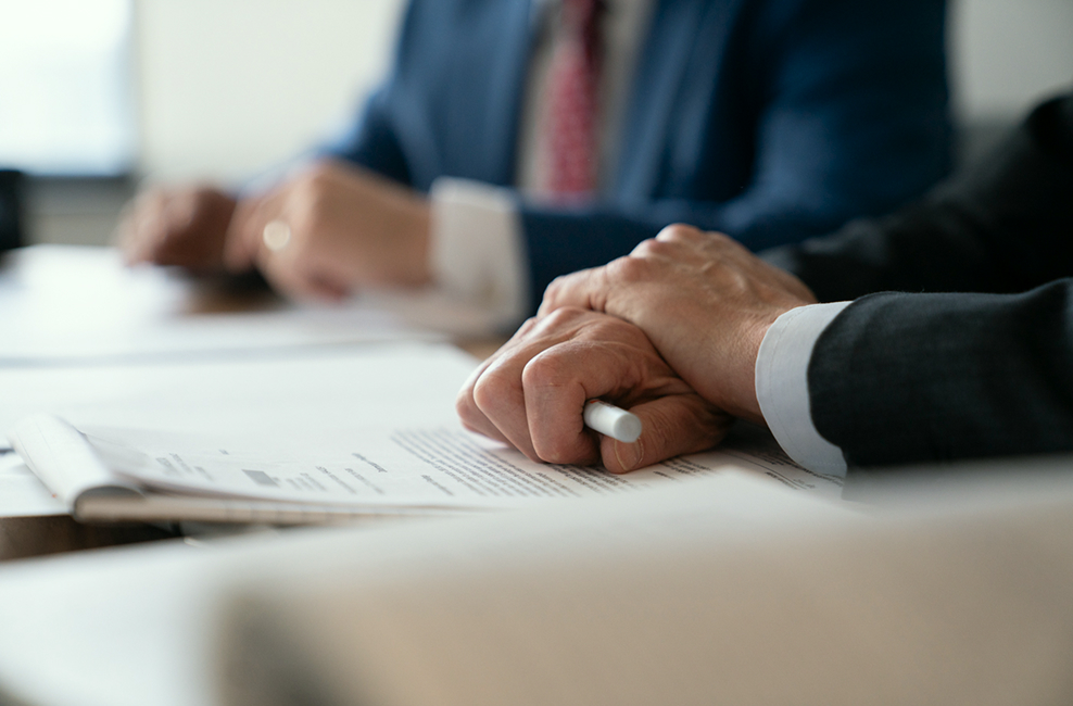 Attorney holding a pen over documents on a conference table