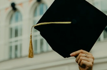 Graduate holding a mortarboard cap