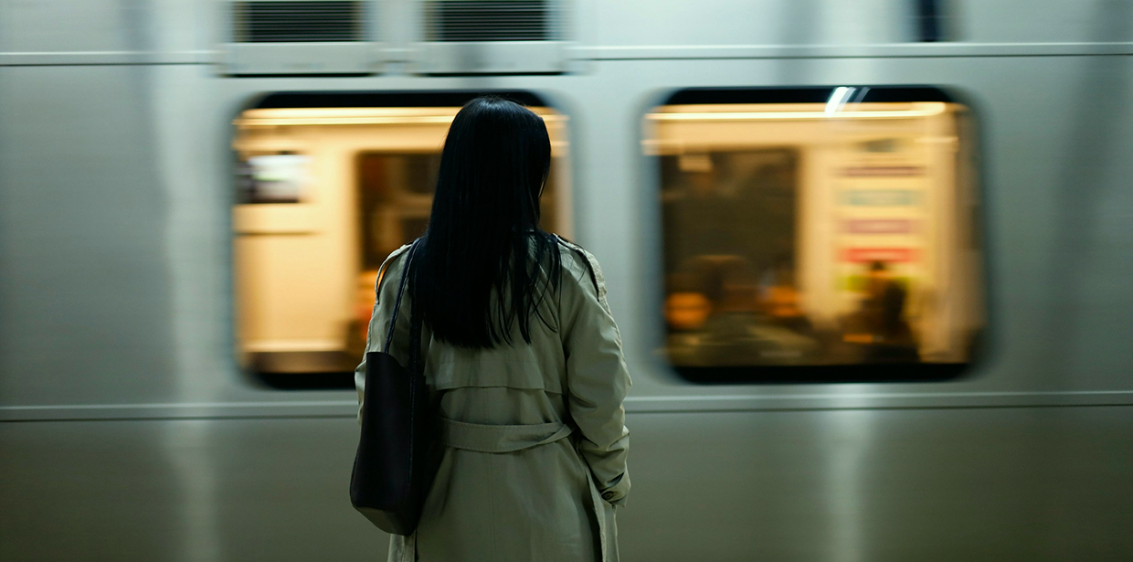 Woman facing a train at a station